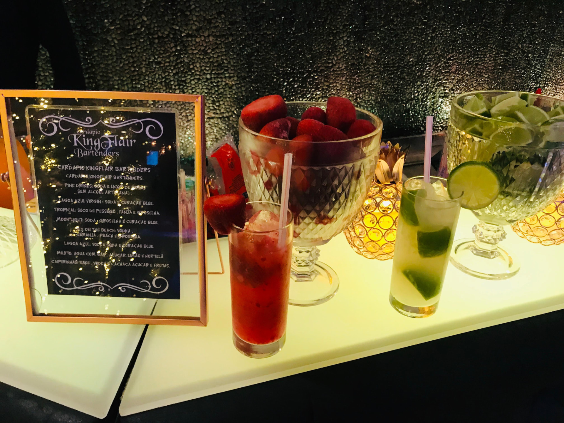 Cardápio KingFlair ao lado de coquetéis e frutas frescas