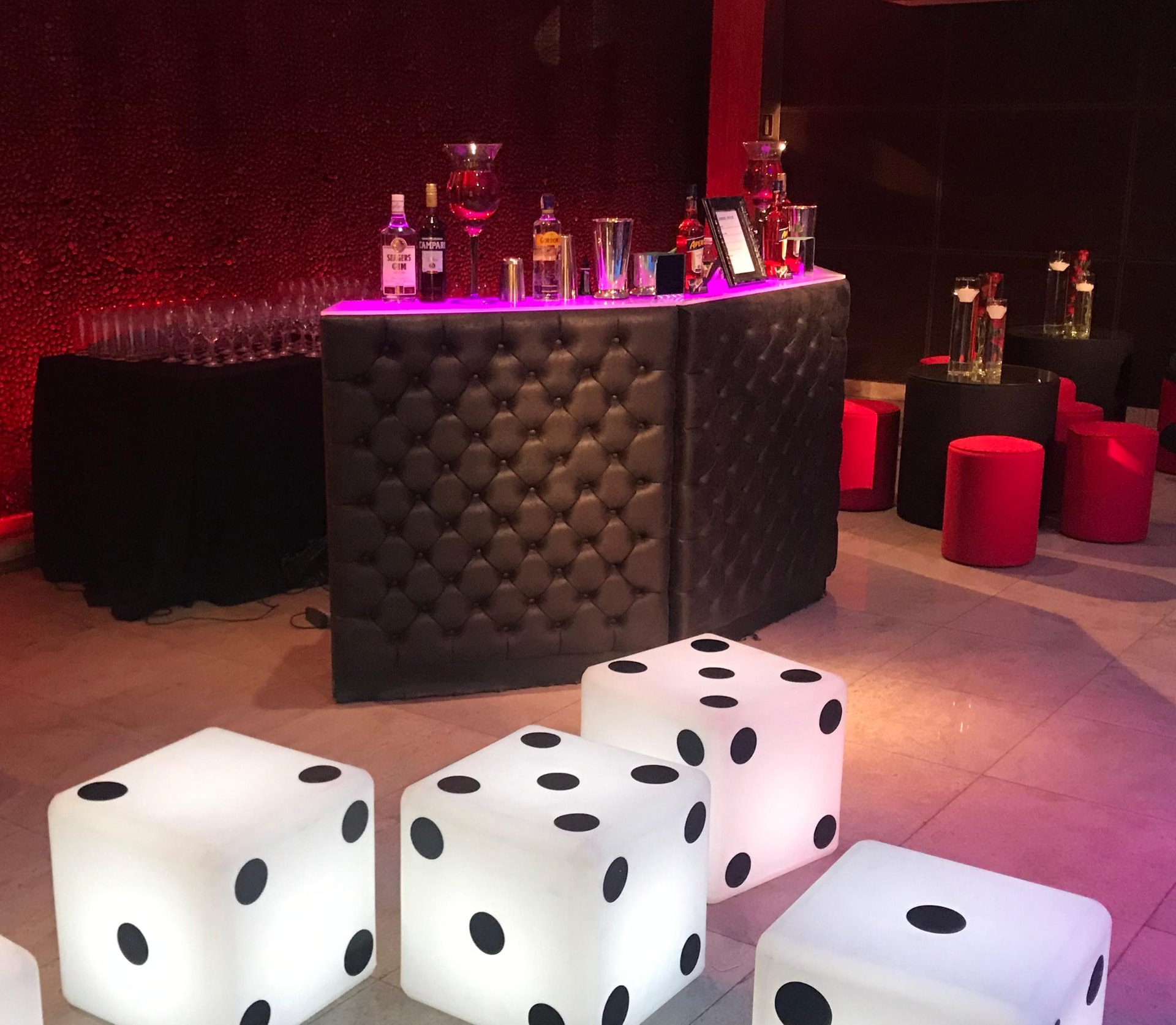 Estrutura de bar capitonê com iluminação em ambiente de festa